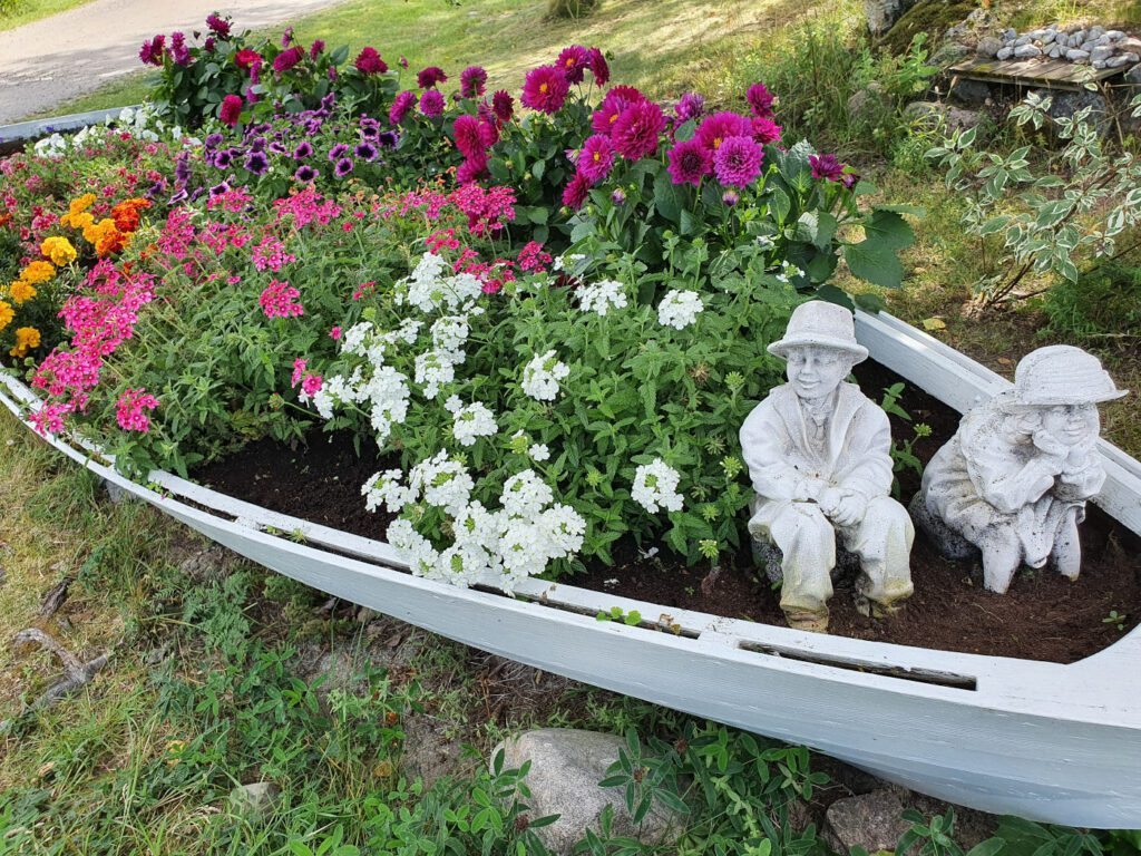Kukkaistutuksia valkoisessa veneessä Livonsaari Caravanilla.