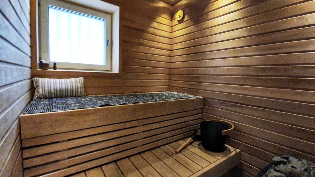 Huoneisto Merikorte sauna, harmaa laudeliina ja musta kiulu.
