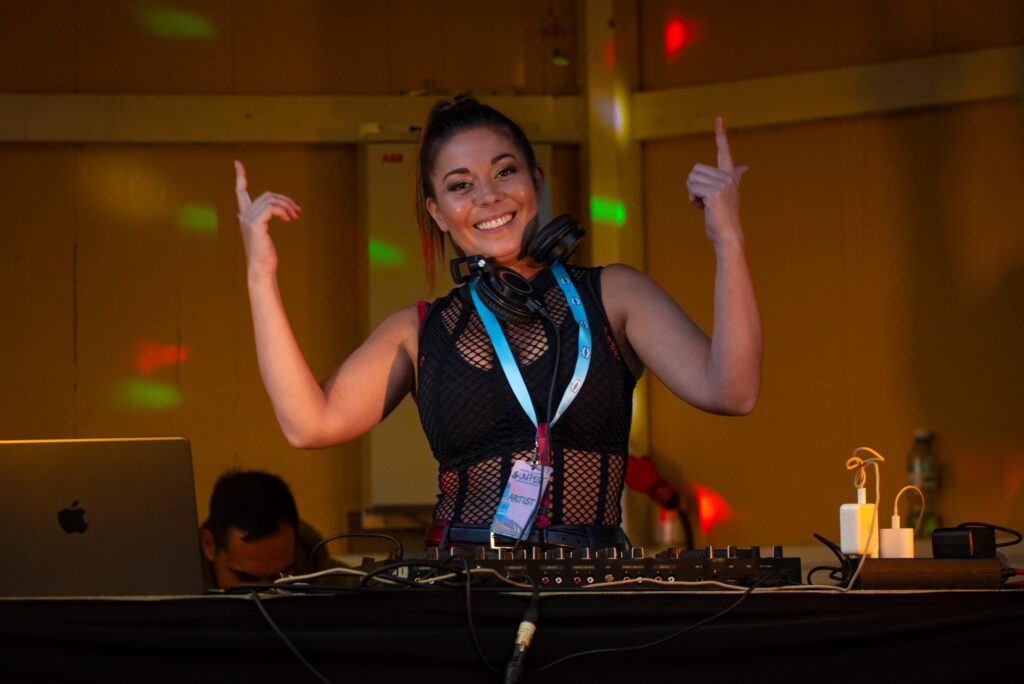 DJ Amanda Harkimo iloisena soittamassa musiikkia Naantali Sunfesteillä.