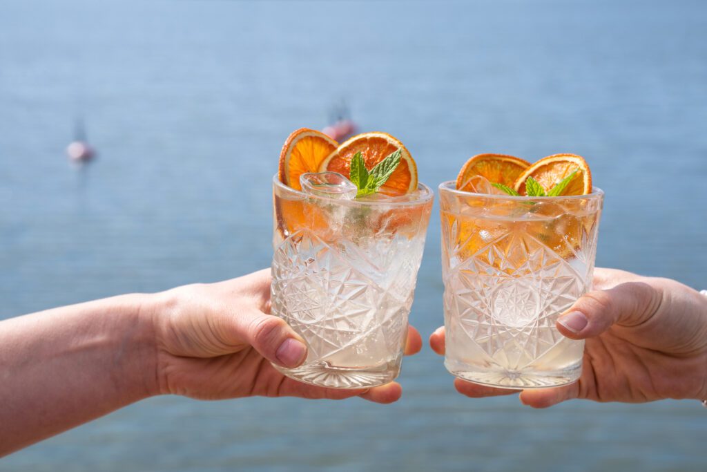 Kaksi cocktailia koristeellisissa laseissa ja appelsiini-koristelut.
