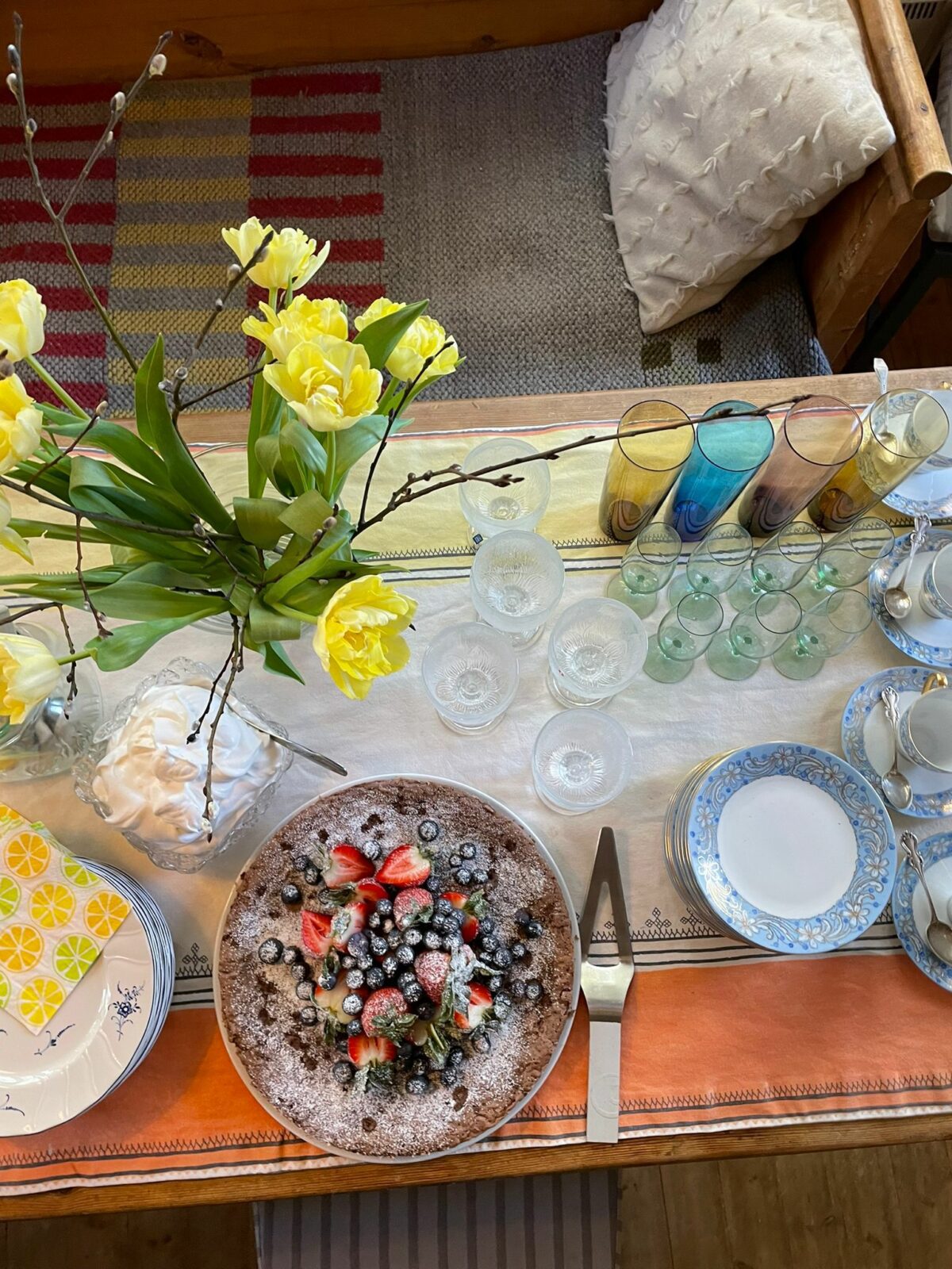 Keväinen ruokapöytä, keltaisia tulppaaneita ja piirakka.