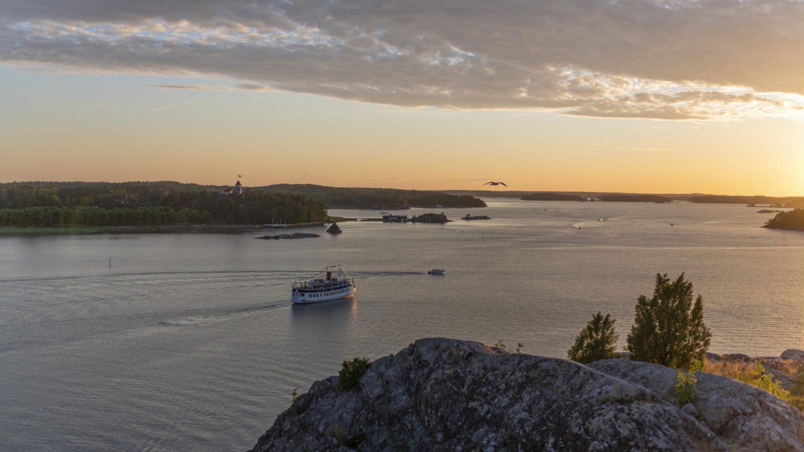 Näkymä merelle ja Kultarantaan Kuparivuoren kallioilta auringon laskiessa ja maalatessa maiseman keltaiseksi.