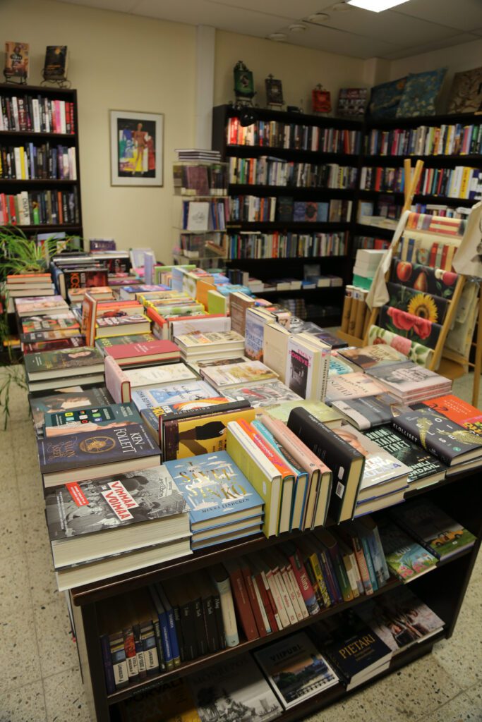 Pieni Kirjapuoti -myymälä sisältä. Kirjahyllyjä sekä pöytiä, joihin aseteltu myyntiin kirjoja.