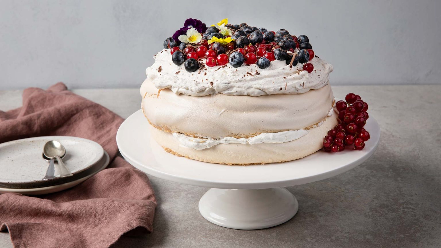 Ruokakummi-Annen pavlova-kakku, joka on koristeltu marjoilla.