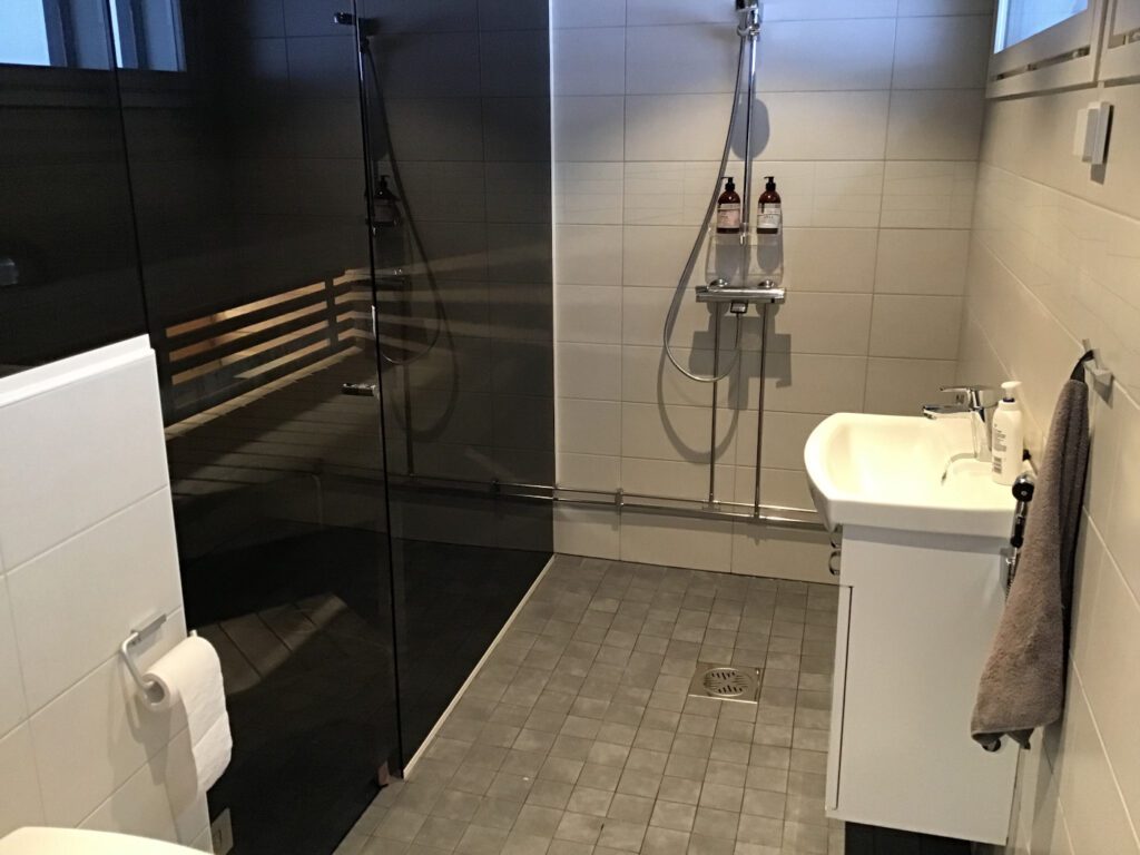 Majoituskohteen moderni suihku sekä tumma sauna.