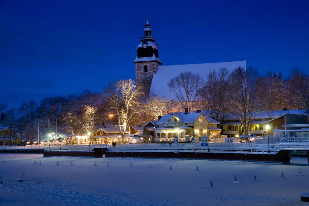 Naantalin kirkko ja ranta rakennuksineen lumisena talvi-iltana.