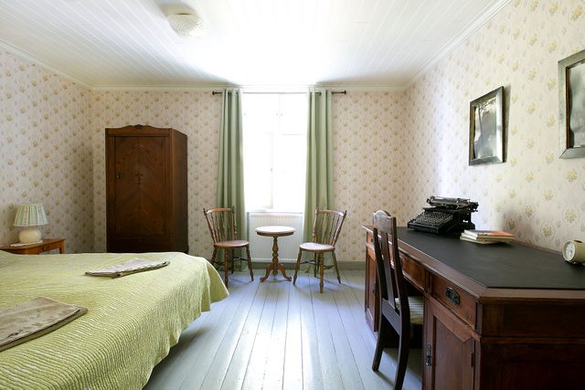 Tammiston B&B:n majoitushuone, joka on sisustettu vanhoilla huonekaluilla sekä vaalean vihreillä sävyillä.