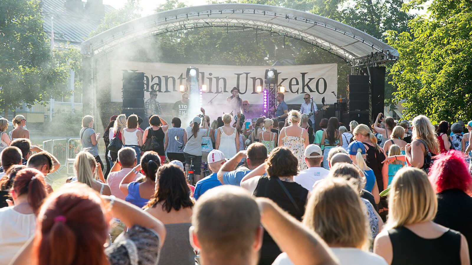 Puistossa olevan Naantalin Unikeko -lava, jolla esiintyjä ja jonka edessä on iso joukko ihmisiä.